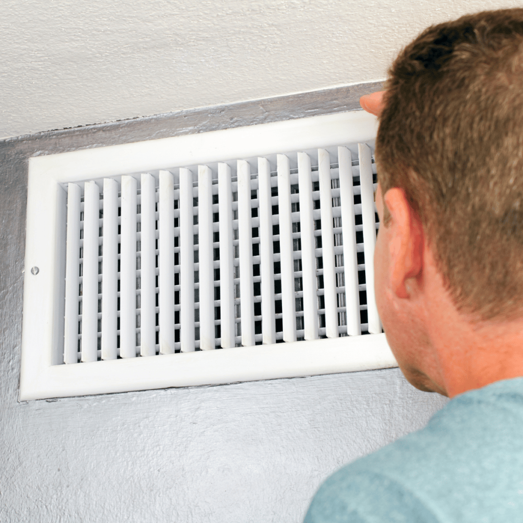 man inspecting his home's air ducts