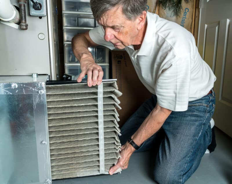 man replacing air filter for heater maintenance