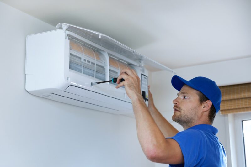 HVAC technician installing an air conditioner inside a home