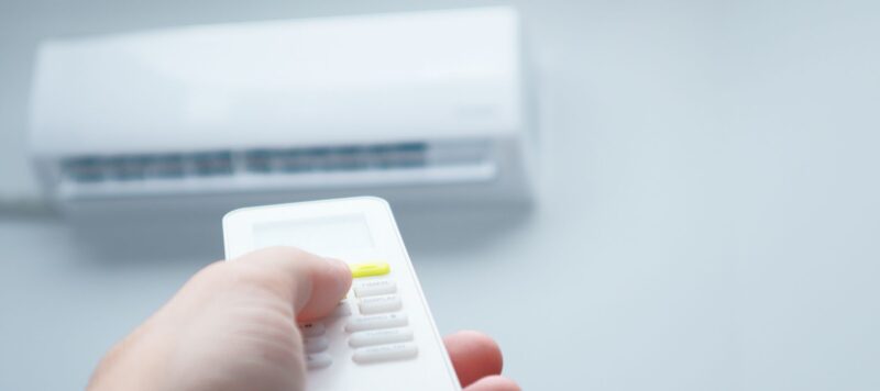 a hand holding a remote to control the interior ductless ac system