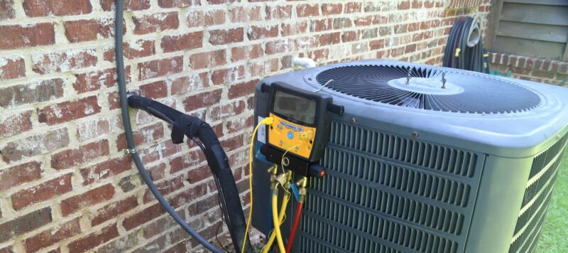 an outdoor AC unit being inspected using tools for seasonal maintenance