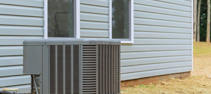 an outdoor ac unit sitting next to the wall of a blue home
